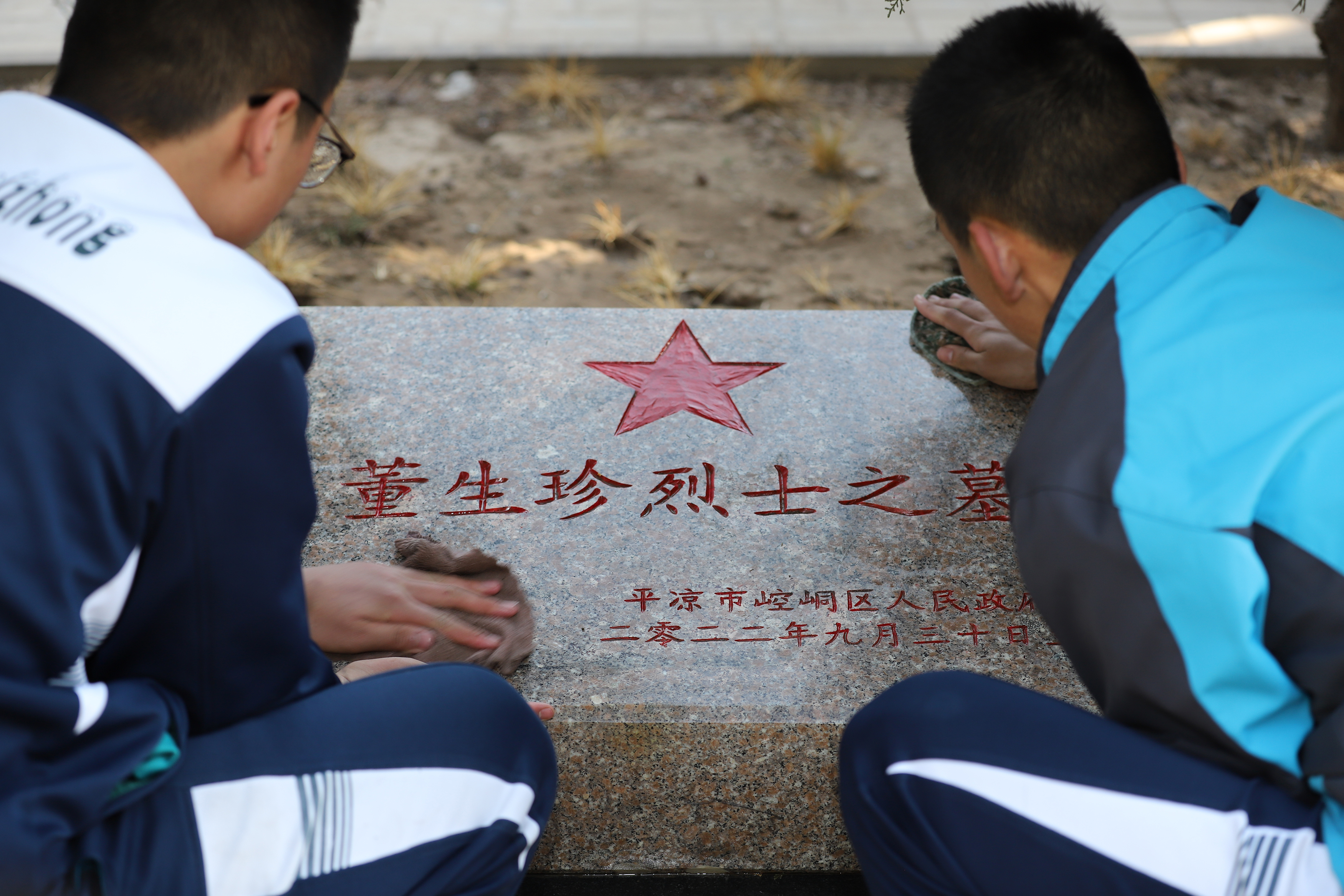 08——3月29日，甘肅省平?jīng)鍪械谒闹袑W(xué)學(xué)生在平?jīng)鍪辛沂苛陥@擦拭烈士墓碑。.JPG