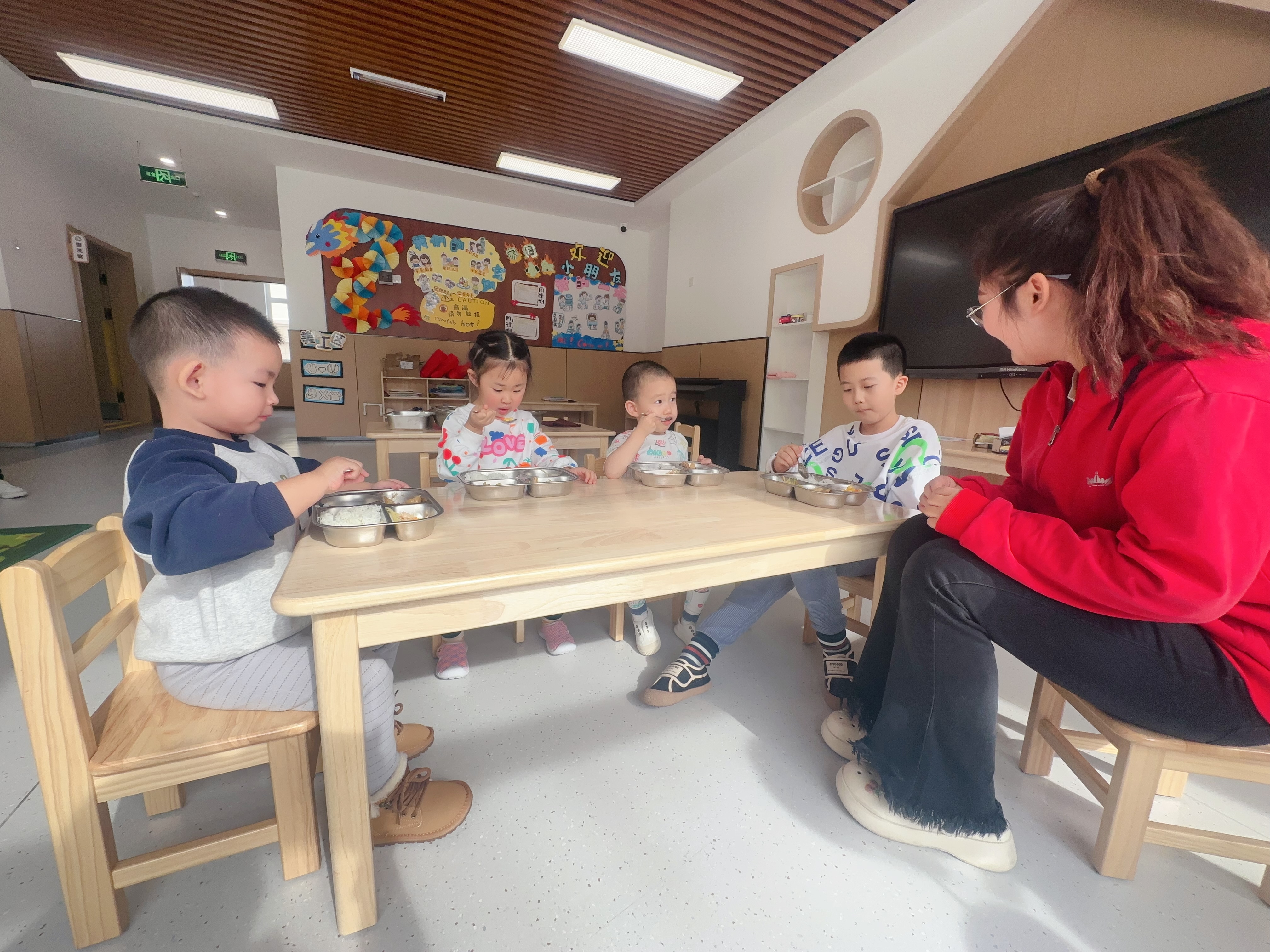 綠園區(qū)第四實(shí)驗(yàn)幼兒園，孩子在開心地吃著園區(qū)精心搭配的營養(yǎng)午餐（綠園區(qū)教育局供圖）.jpg