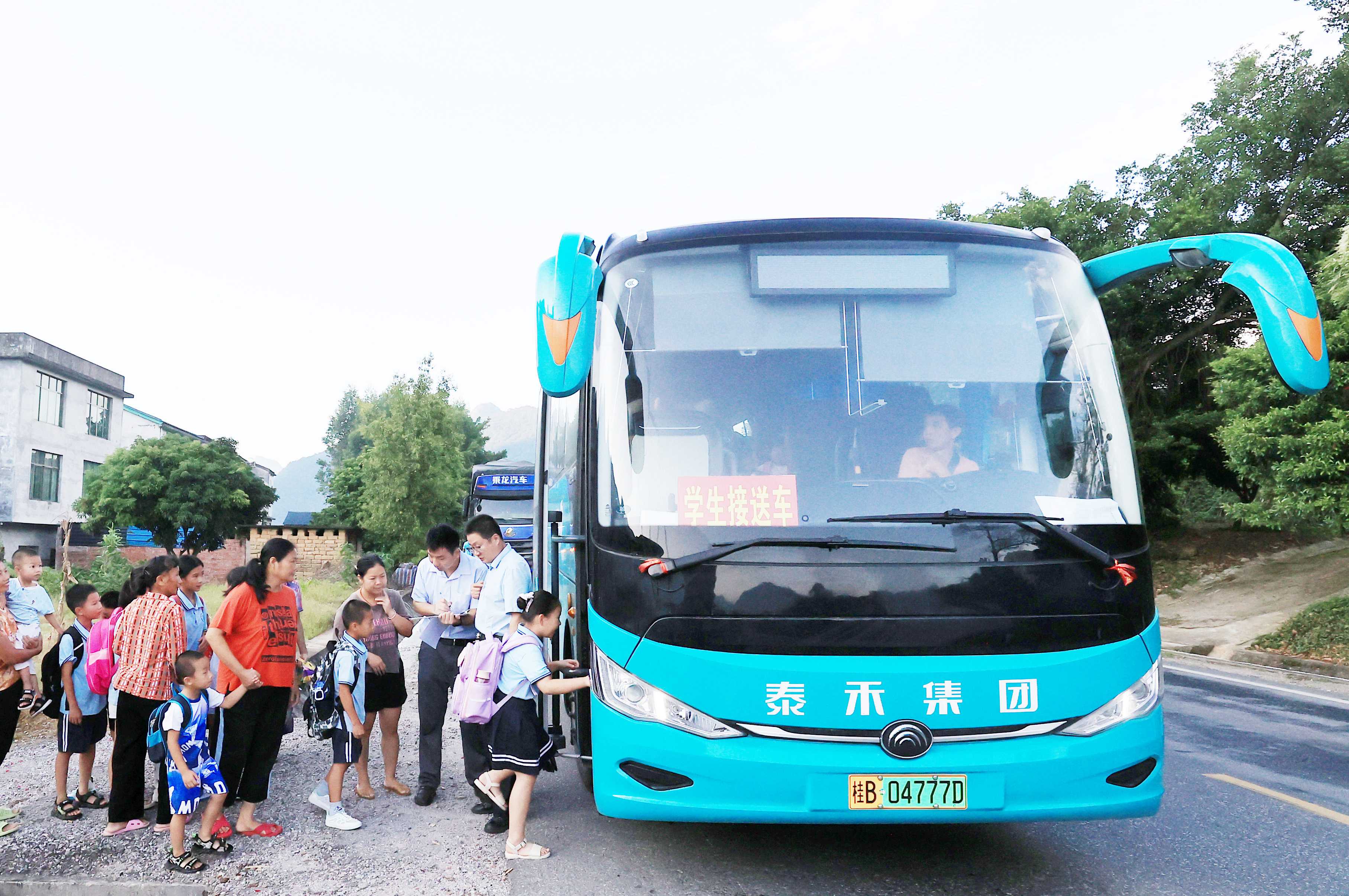 圖2：9月2日早晨，在廣西柳州市融安縣浮石鎮(zhèn)諫村村，工作人員在核對乘車人員名單，準備送學生去學校讀書。（譚凱興 攝）.JPG